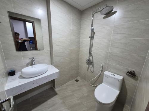 a bathroom with a toilet and a sink and a shower at BenHill - serviced apartment-Binh Duong in Ấp Dừa