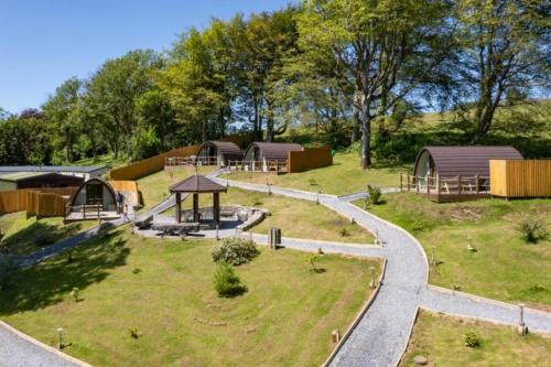 a park with a playground with buildings and trees at Pods @ Broadway in Laugharne