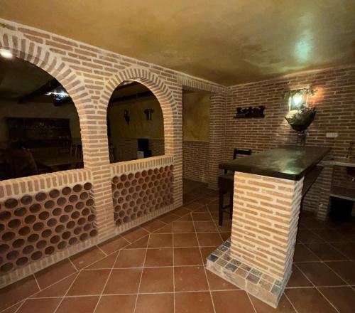 a room with a brick wall with a table in it at Apartamentos San Gabriel in Alcalá de Henares