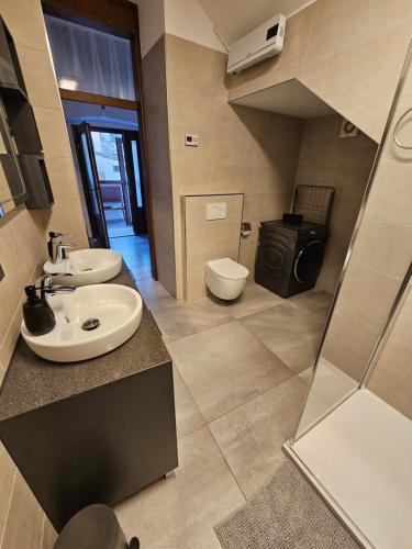 a bathroom with two sinks and a toilet at Mark & Lana in Sežana