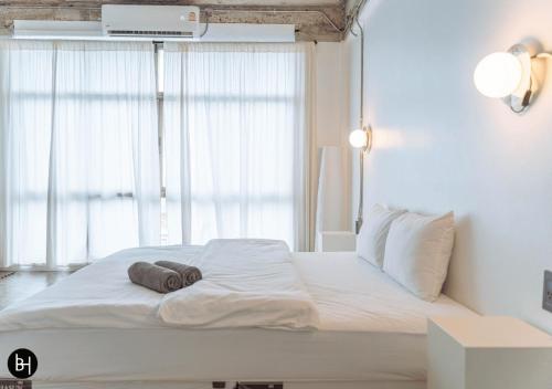 a white bed in a room with a window at BAAN650 Hostel in Hat Yai