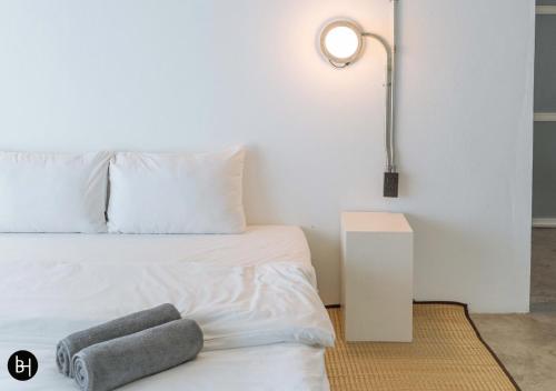 a bedroom with a white bed with two towels on it at BAAN650 Hostel in Hat Yai