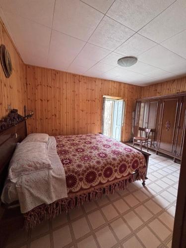 a bedroom with a bed in a room with wooden walls at Dai Nonni Vacation Home in Acciano