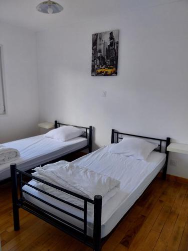 two beds in a room with a picture on the wall at Le Dom'Mino in Condé-Folie