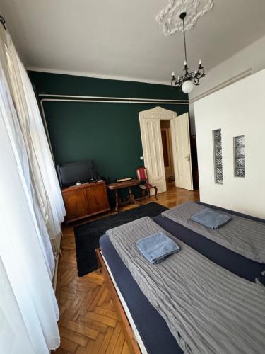 a bedroom with two beds and a green wall at Lyrius Vendégház - Debrecen in Debrecen