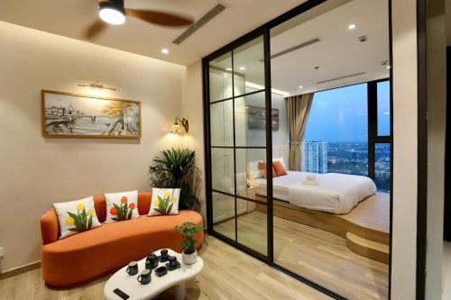 a room with a couch and a bed and a window at Maison de Ecopark - Onsen & Spa in Kim Quan