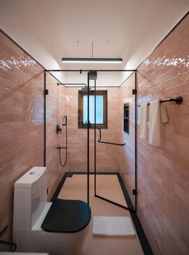 a bathroom with a shower and a toilet at Botanique Goa in Assagao