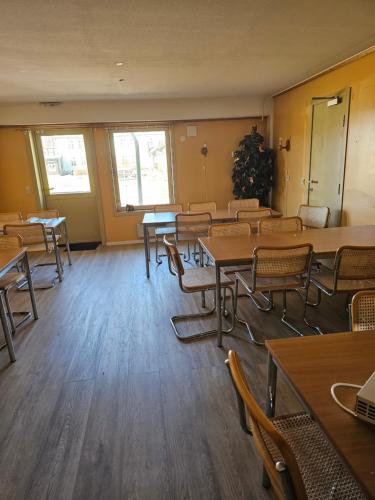 a classroom with tables and chairs in a room at Vertshuset gamlebirkeli in Drilen