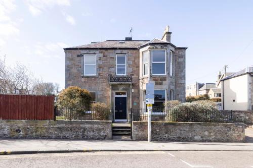 an old brick house on the side of a street at Detached House with Sea Views & Parking in North Berwick