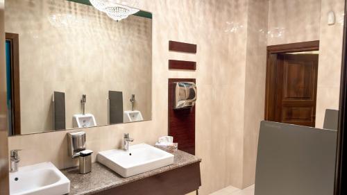 a bathroom with two sinks and a mirror at Hotel Zodiac by Sofra in Constanţa