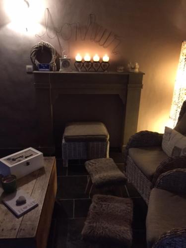 a living room with a couch and a fireplace at Gîte de Corbion une envie d'Ailleurs 6personnes et le Pt Bonheur 2 personnes in Leignon