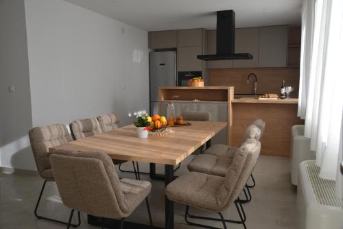 a kitchen with a wooden table and chairs with fruit on it at Pax et Bonum in Lozovac