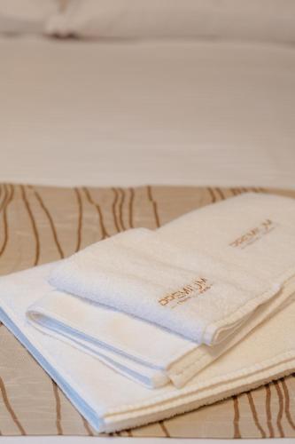 a stack of towels sitting on a bed at Central Premium Suites in Plovdiv