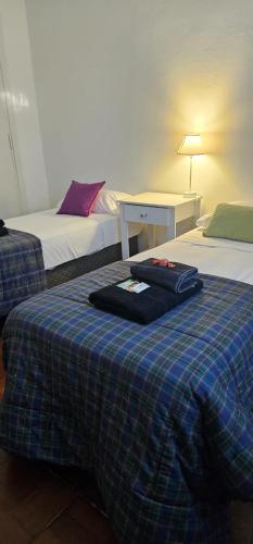 a hotel room with two beds with a blue plaid blanket at Casa belgrano Lobos in Lobos