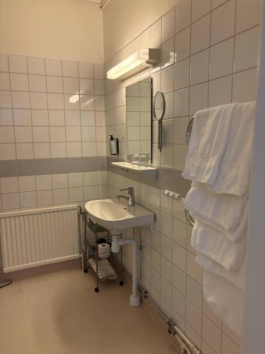 a bathroom with a sink and a mirror and towels at Bångbro Herrgård in Kopparberg