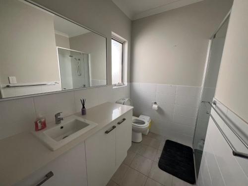 a white bathroom with a sink and a toilet at Sweet Home Property 7A Kewdale in Perth