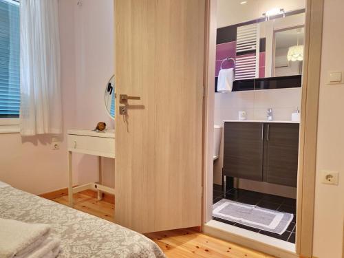 a bedroom with a door leading into a bathroom at Peonia Flower House in Asprogerakata
