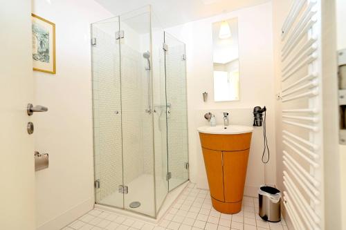 a bathroom with a glass shower and a sink at Appartement Moin! in Hohwacht