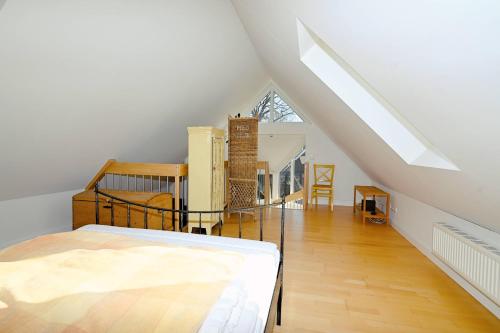 a attic room with a bed and a staircase at Appartement Moin! in Hohwacht