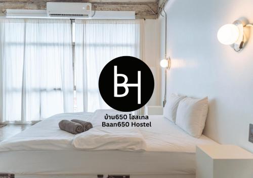 a bed with a black and white sign on it at BAAN650 Hostel in Hat Yai
