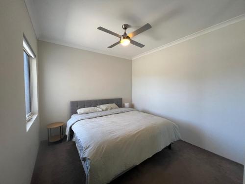 a bedroom with a bed with a ceiling fan at Sweet Home Property 7A Kewdale in Perth