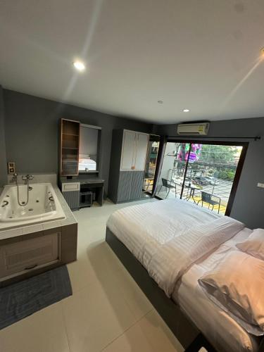 a bedroom with a bed and a tub and a sink at Vera House in North Pattaya