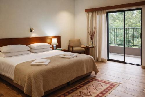 a bedroom with a large bed with two towels on it at Kallithea INN in Platres