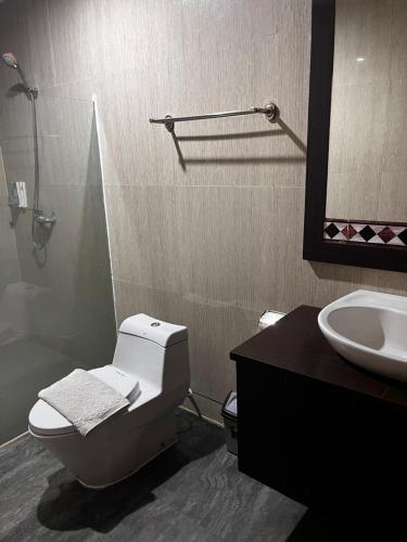 a bathroom with a toilet and a sink at Miracle Hotel Manado in Manado