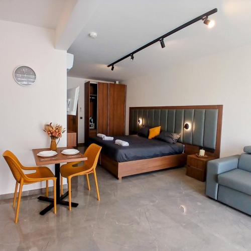 a bedroom with a bed and a table and a couch at The Black Onyx in Il-Gżira