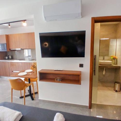 a living room with a large flat screen tv on a wall at The Black Onyx in Il-Gżira