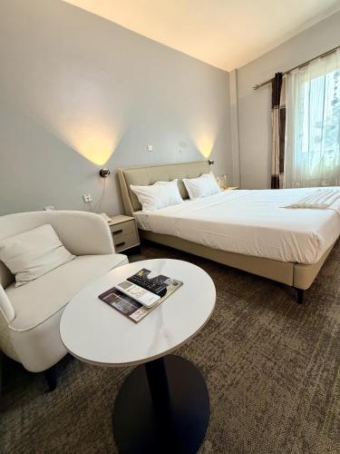 a hotel room with a bed and a couch and a table at James Hotel & Apartments in Juba