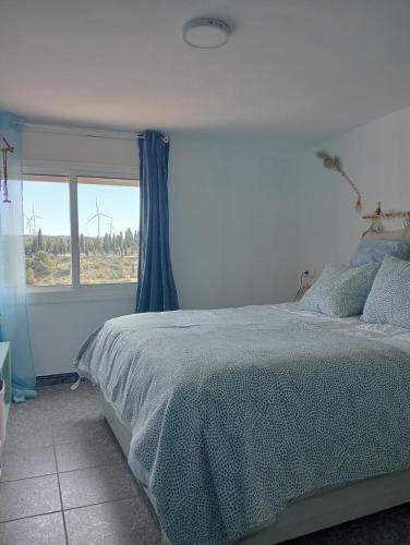 a bedroom with a bed and a window at Ca la Carme in Villalba dels Arcs