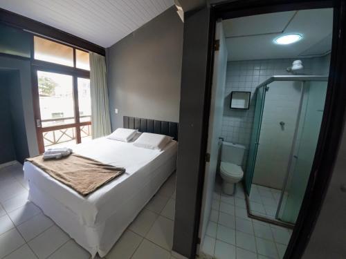 a bedroom with a bed and a shower and a toilet at Pousada Maraca Beach in Porto De Galinhas