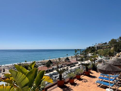 a view of the beach from the balcony of a resort at Apartamentos HC Burriana Playa in Nerja