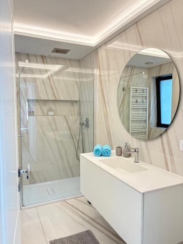 a bathroom with a white sink and a shower at Seaside Escape in Trieste