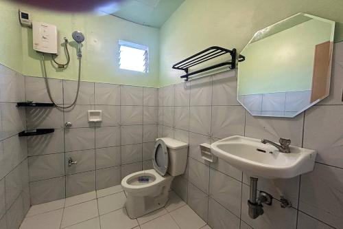 a bathroom with a toilet and a sink and a mirror at Lazy Daze Hometel Boracay in Boracay