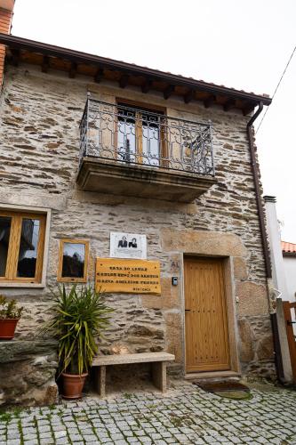 a building with a balcony and a bench in front of it at Casa do Lagar in Vale do Porco