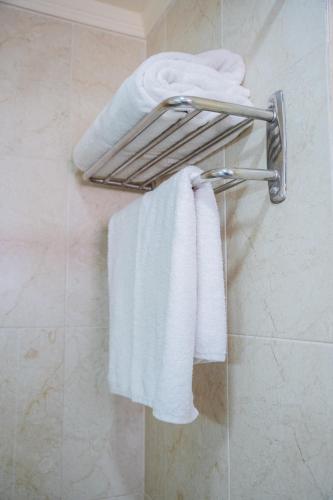 a group of towels hanging on a towel rack in a bathroom at Fanar Hotel in Ain Sokhna