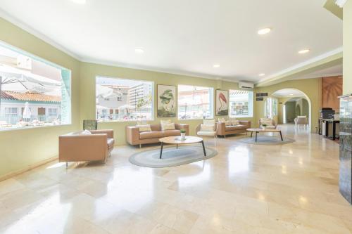 a lobby with couches and tables and windows at BLUESEA Miramar Fuengirola in Fuengirola