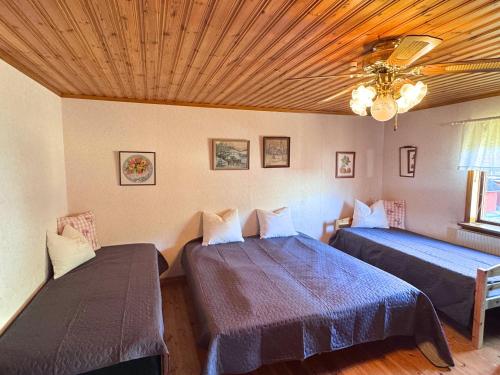 a bedroom with two beds and a ceiling at Hus Stora Hultet in Hultsfred
