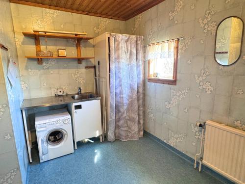 a laundry room with a washer and a sink at Hus Stora Hultet in Hultsfred