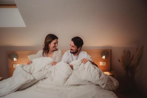 a man and a woman laying in bed at Les Doms d'Alfred - GRINDOM in Plombières