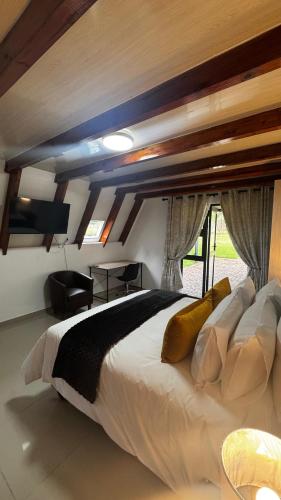 a bedroom with a large white bed and a window at The Swiss Garden in Midrand