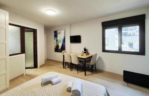 a bedroom with a bed and a table with chairs at Premium Luxury Muralla de Lugo 2.3-A in Lugo