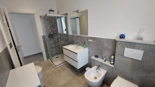 a bathroom with a sink and a toilet and a mirror at La Pineta, 26 - 5 in Casarza Ligure