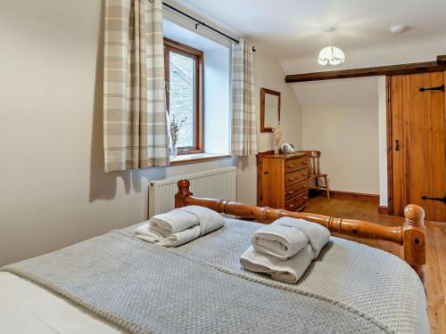 two towels on a bed in a bedroom with a window at 2 Bed in Crickhowell oc-mawrw in Cwm-du