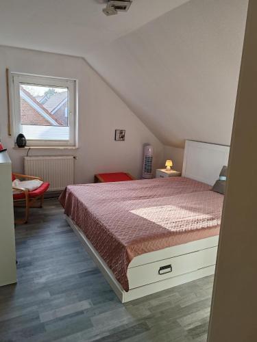 a bedroom with a bed and a window at Haus Amsel am Heeder See in Heede