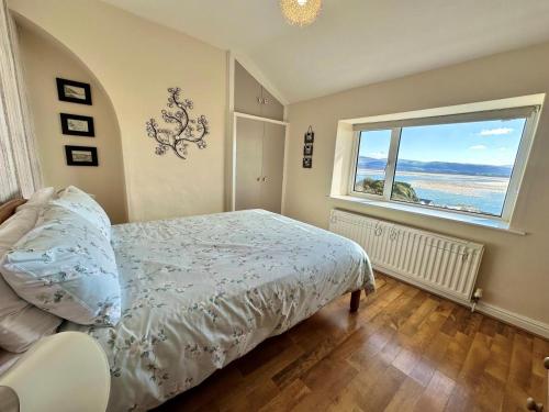 a bedroom with a bed and a large window at 3 Bed in Aberdyfi oc-dy024 in Aberdyfi