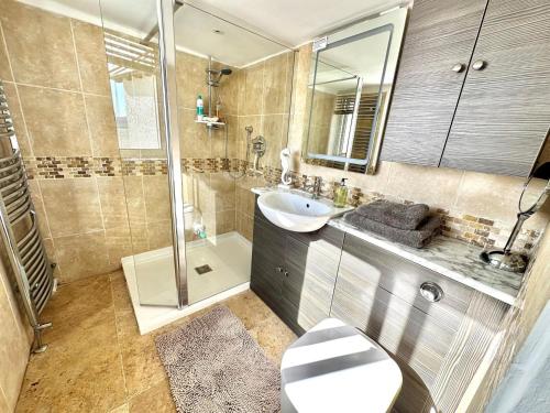 a bathroom with a sink and a shower and a toilet at 3 Bed in Aberdyfi oc-dy024 in Aberdyfi