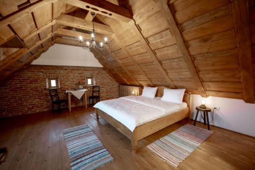 a bedroom with a bed and a brick wall at Azuria Viscri in Viscri